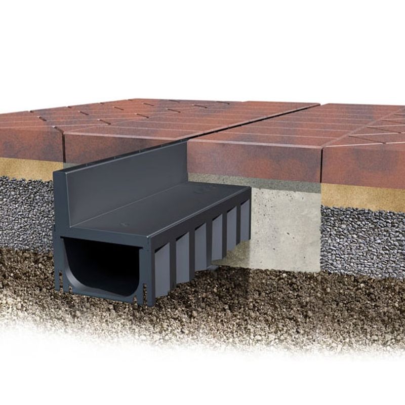A cut out view of the ACO HexDrain Brickslot channel installed in brick paving.