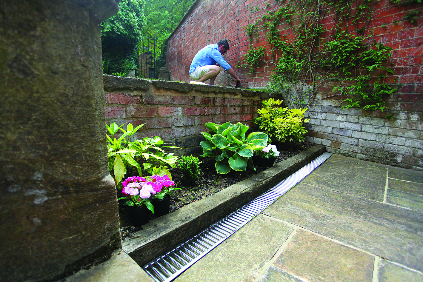 ACO Hexdrain galvanised grating & channel installed in garden patio for optimal run-off management.